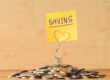 Pile of coins with saving label on a wooden table. Financial Concept.