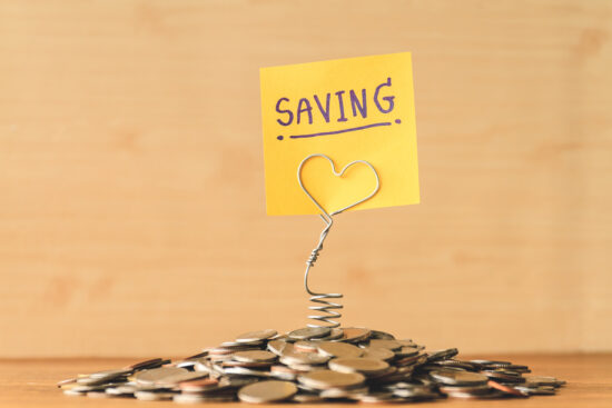 Pile of coins with saving label on a wooden table. Financial Concept.